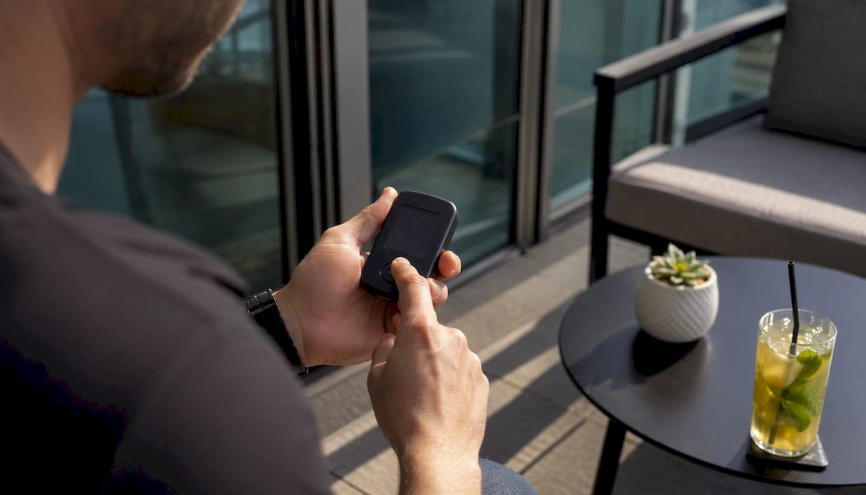 Hands pressing cold wallet button to confirm transaction