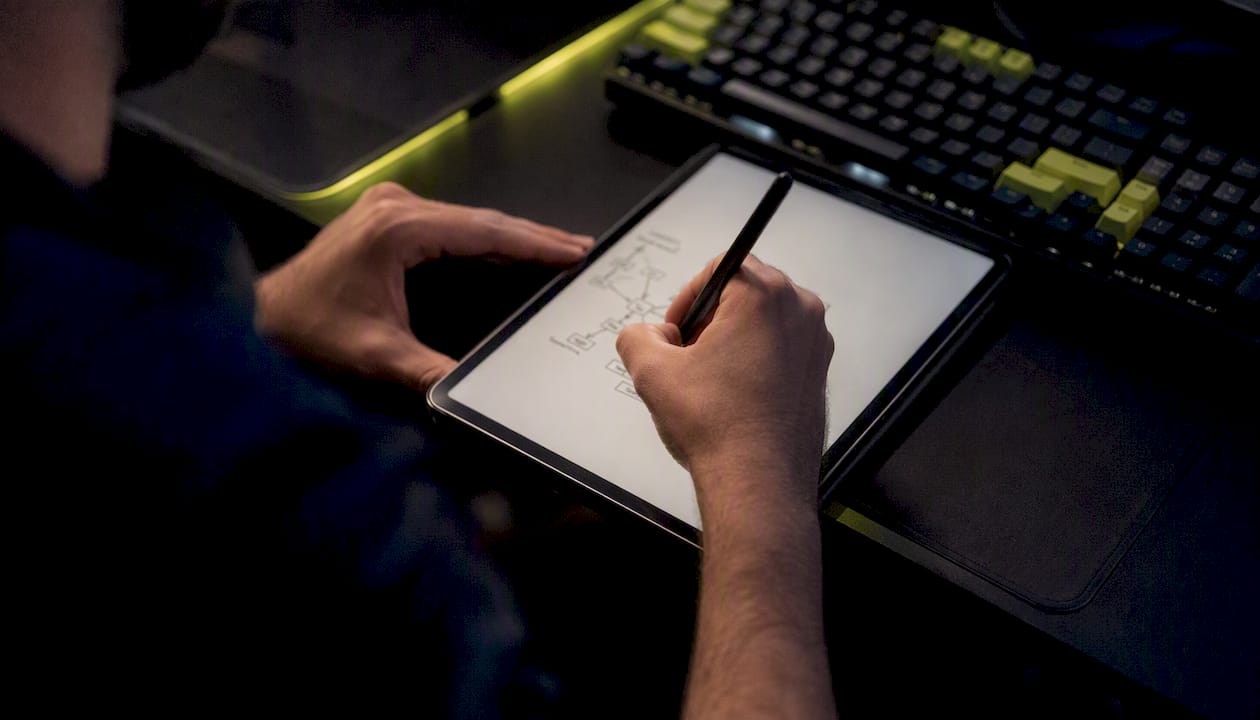 Hands writing regression test code on digital tablet