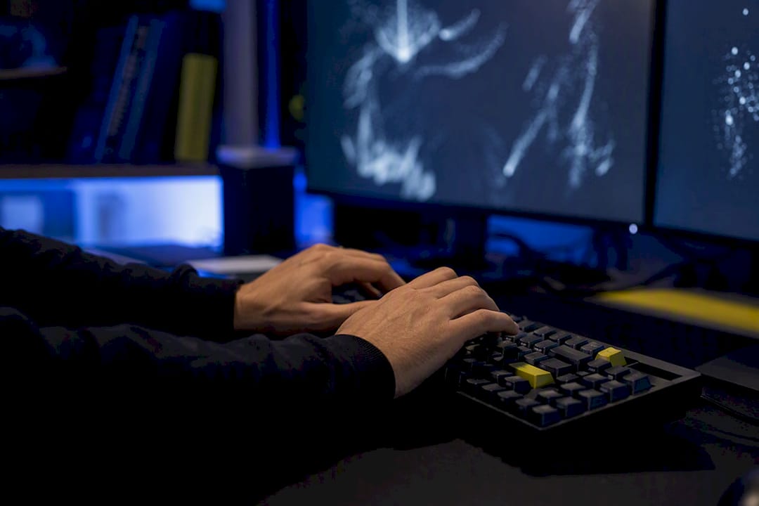 Hands typing blockchain smart contract code in dark room
