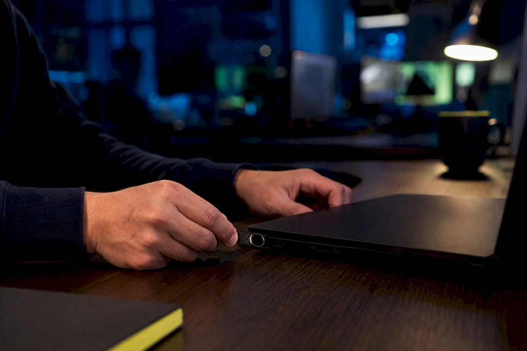 Hands inserting hardware security token into USB port