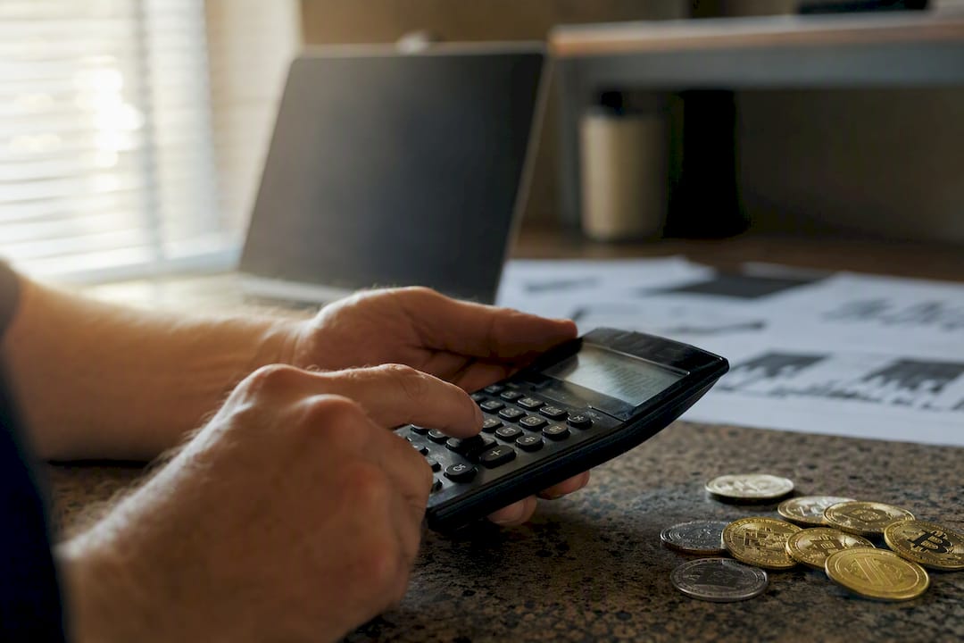 Hands calculating crypto loss with calculator