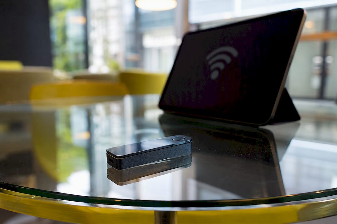 Partial hardware wallet near smartphone showing Bluetooth risk
